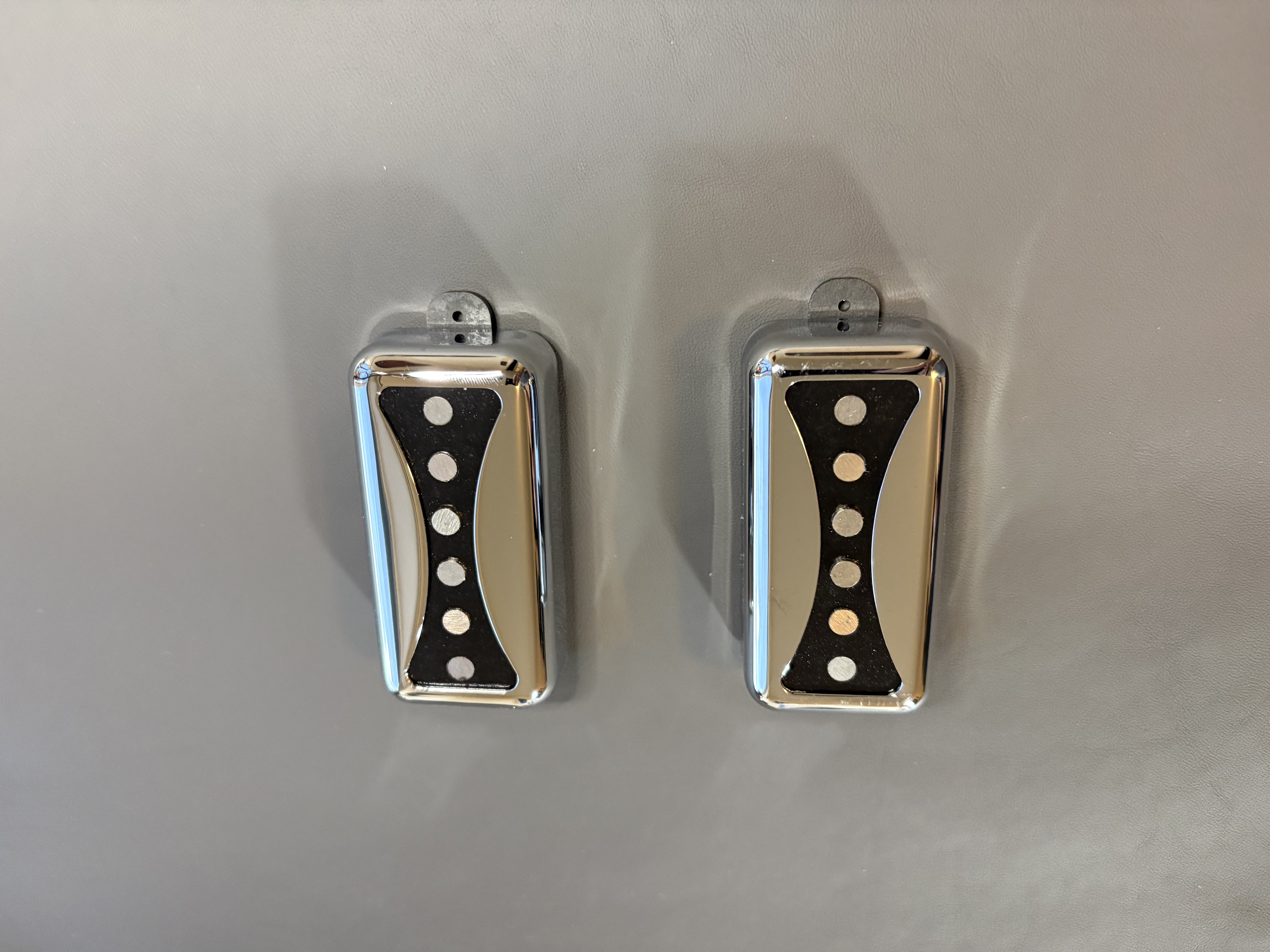 Pair of chrome-covered Arcform Bowtie pickups, front view, showing the bowtie cutout with five exposed alnico magnet poles