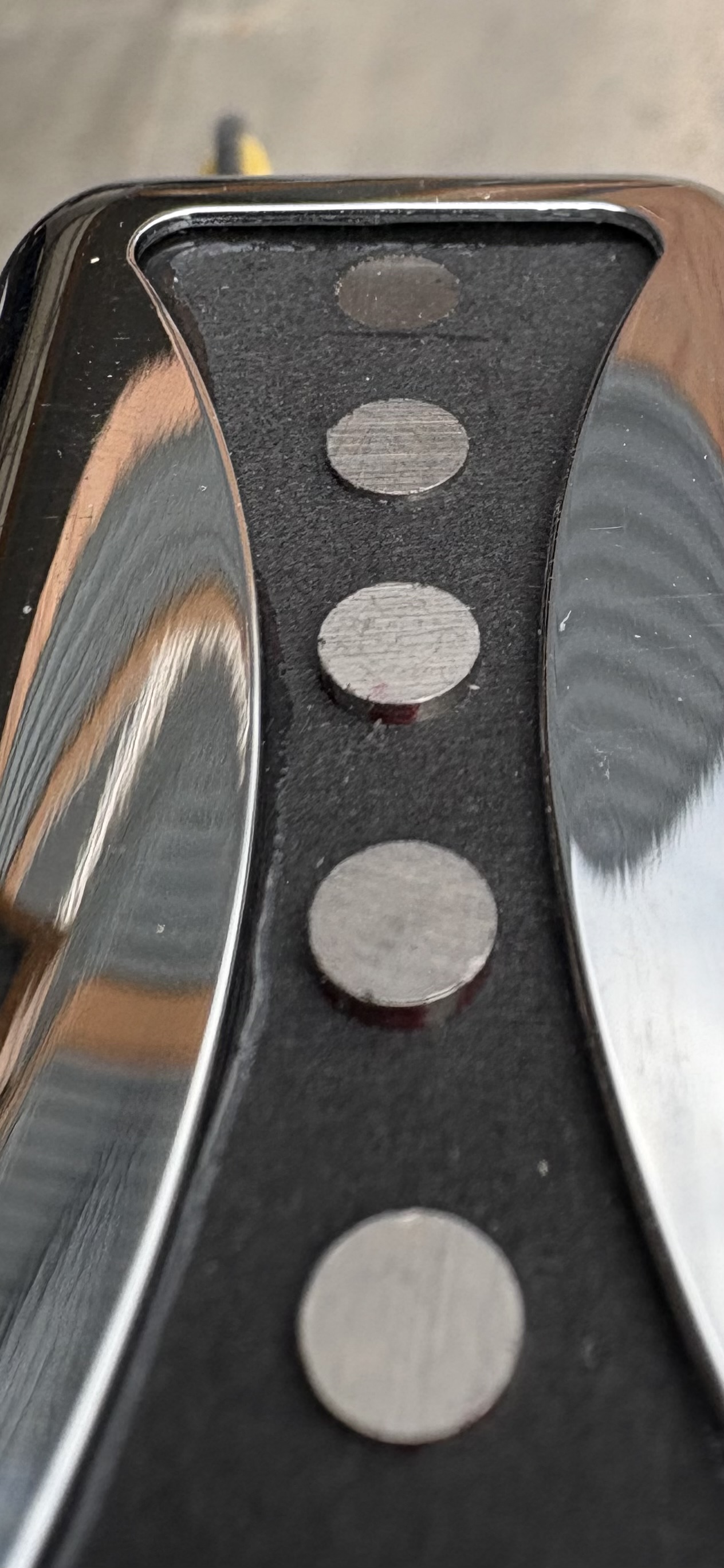 Macro view of five alnico magnet poles seated through the bowtie cutout of an Arcform Bowtie pickup